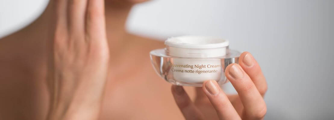 Model applying night cream